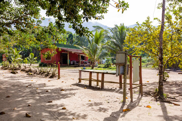 House in the Castelhanos beach Ilhabela, tropical trees and travelers, in famous paradise on Sao Paulo coast in Brazil