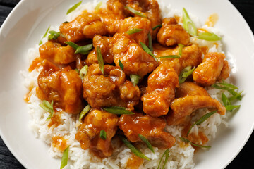 Chinese orange chicken with rice and green onion garnish