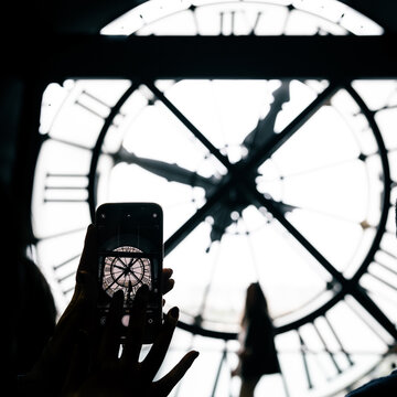 Paris, France: Orsay Museum Clock with silhouette of tourists taking picture