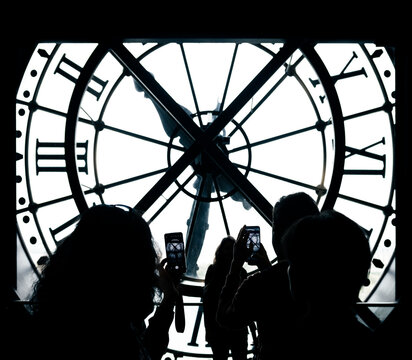 Paris, France: Orsay Museum Clock with silhouette of tourists taking picture