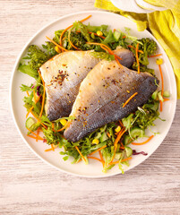 fish fillets over salad