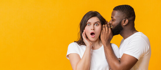 African American Man Sharing Secret With His Girfriend. Surprised Woman Opened Mouth In Shock,...