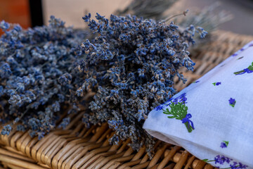 A close-up of dried lavender bunches displayed alongside a lavender-embroidered fabric, capturing the essence of local herbs and crafts.