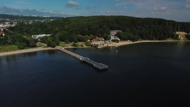 A breathtaking aerial view showcases a serene pier extending gracefully into calm, inviting waters