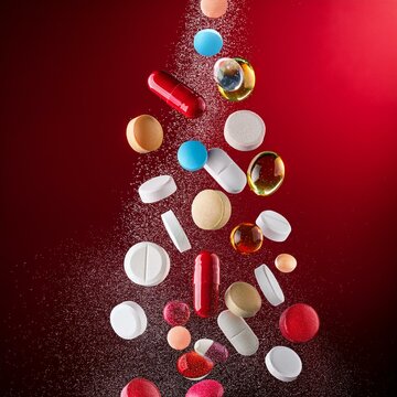 P&iacute;lulas, c&aacute;psulas e comprimidos dispostos aleatoriamente, mostrando a diversidade de medicamentos e suplementos.