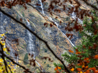 Autumn Branches Framing a Cascade in Belledonne Massif