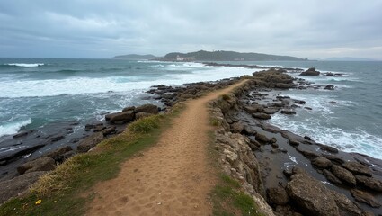 Scenic coastal path with crashing waves secluded beach and distant lighthouse