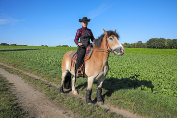 Westernreiten - Reiterin mit Cowboyhut mit Ihrem Pferd