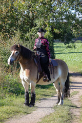 Westernreiten - Reiterin mit Cowboyhut mit Ihrem Pferd