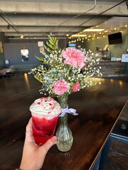 Flowers in a vase paired with a red drink