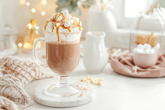 Caramel latte topped with marshmallows and caramel drizzle in a cozy kitchen