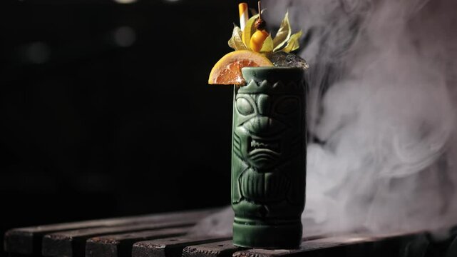 Tiki-style cocktail with citrus and decorative smoke