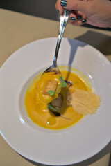 Spoonful of Flavorful Pumpkin Soup with Crouton and Microgreens
