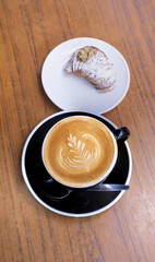 Breakfast in a cafe. This image captures a simple, everyday moment, where the pleasure of a good coffee and a freshly baked cake combine with the calm of a relaxed environment.