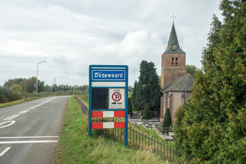 Place name sign for the village of Dodewaard, the Netherlands (also no parking for trucks or buses in this zone)