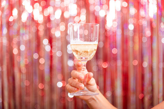 Toasting with champagne on New Year's Eve with colorful backdrop