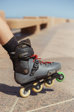 Cropped unrecognizable young person rollerblading on inline skates