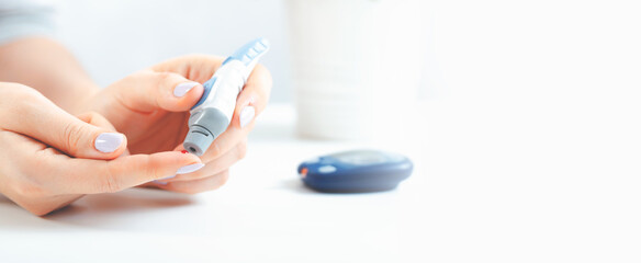 Woman is holding a glucometer