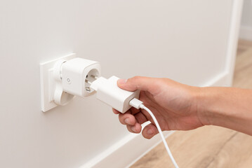Man plug charger into smart socket