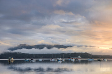 Fog hangs over sailboats and floating houses anchored in Cowichan Bay, off Vancouver Island; Duncan, British Columbia, Canada