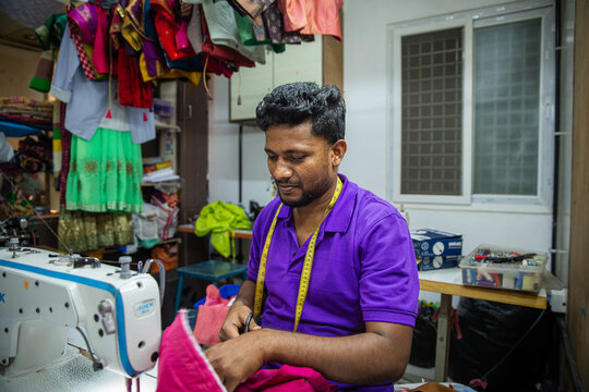 Man working on fabric with sewing machine.