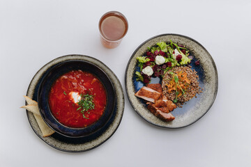 Traditional Ukrainian borscht paired with buckwheat, chicken, and beet salad for a hearty meal
