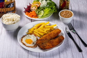 breaded chicken with eggs, fries and vegetables