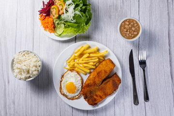 breaded chicken with eggs, fries and vegetables