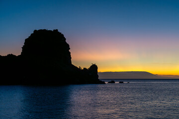 Brightly colored sunset over a silhouetted island in the Galapagos