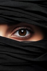 Naklejka premium Close-up of a woman's eye partially covered with black fabric.