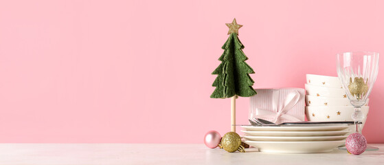 Decorated Christmas table setting on pink background