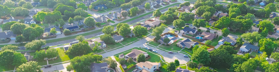 Drainage concrete channel in lush greenery residential neighborhood in Coppell Texas Dallas Fort Worth metroplex, row of detached single-family houses swimming pool, large backyard, grassy lawn