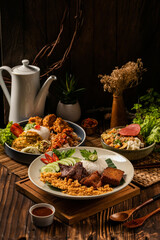 Indulge in a feast of rich flavors!  From crispy fried chicken to savory beef, sambal, and fresh sides