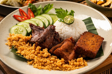 Sego Ayam Bacem is a traditional Indonesian food, consisting of grilled chicken in soy sauce, bacem tofu and tempeh, kremesan, rice and complementary vegetables.