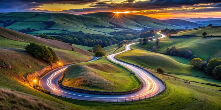 A winding road through rolling hills at sunset, with the sun's rays breaking through the clouds