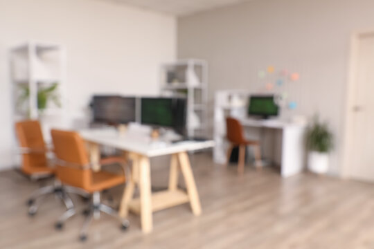 Blurred view of light office with programmer's workplaces