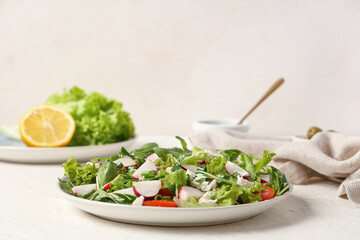 Plate with tasty salad on light table