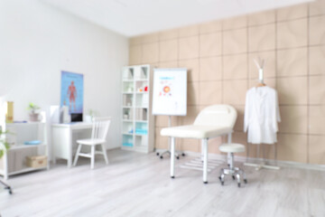 Blurred view of medical office with couch and doctor's workplace