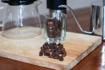 A man making a drip coffee or v60 method, pouring hot water from kettle over a ground coffee powder...