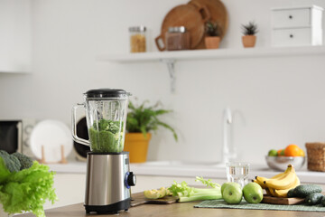 Blender with ingredients for tasty smoothie on table in kitchen
