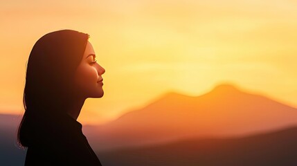 Woman silhouette against a scenic sunset background.