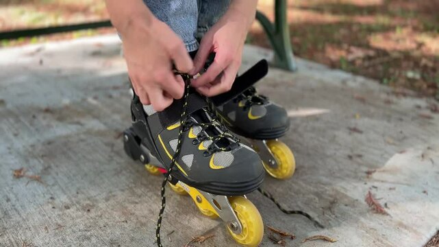 Young fit woman wearing roller skates riding outdoors on urban street. Smiling girl with rollerblading on sunny day close up of hands and roller blades.