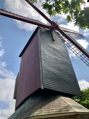 Historic Windmill Against a Blue Sky with Leafy Tree Border