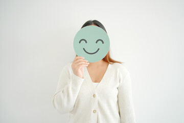 young Asian woman cover her face with smile emoji face, positive mental health, world mental health...