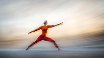 Obraz premium A woman practices yoga in a warrior pose against a blurred sunset sky.