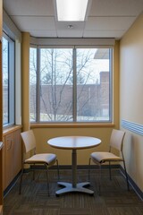 Fototapeta premium A study room with a small round table and two chairs. This setup invites group study sessions or quiet discussions