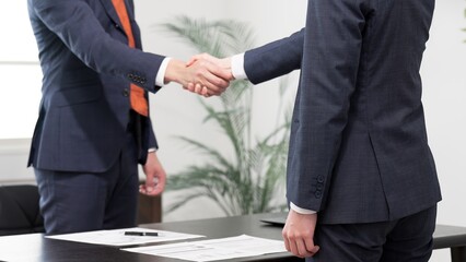 ミーティングで握手をするビジネスマン