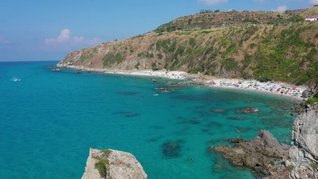 Aerial view of sea and rocky beach in Marinella Di Zambrone on a sunny summer day in Calabria, Italy