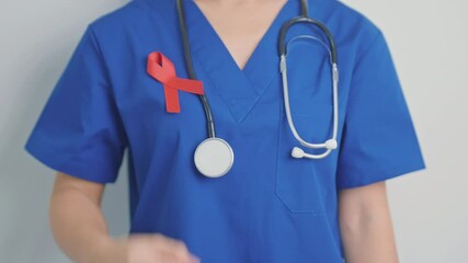 Doctor with Red Ribbon for December World Aids Day, acquired immune deficiency syndrome, multiple myeloma Cancer Awareness month and National Red ribbon week. Healthcare and world cancer day concept