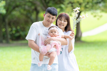 A Taiwanese couple in their 20s and their 7-month-old baby celebrate a birthday in a vast green park in Yilan County, Taiwan.